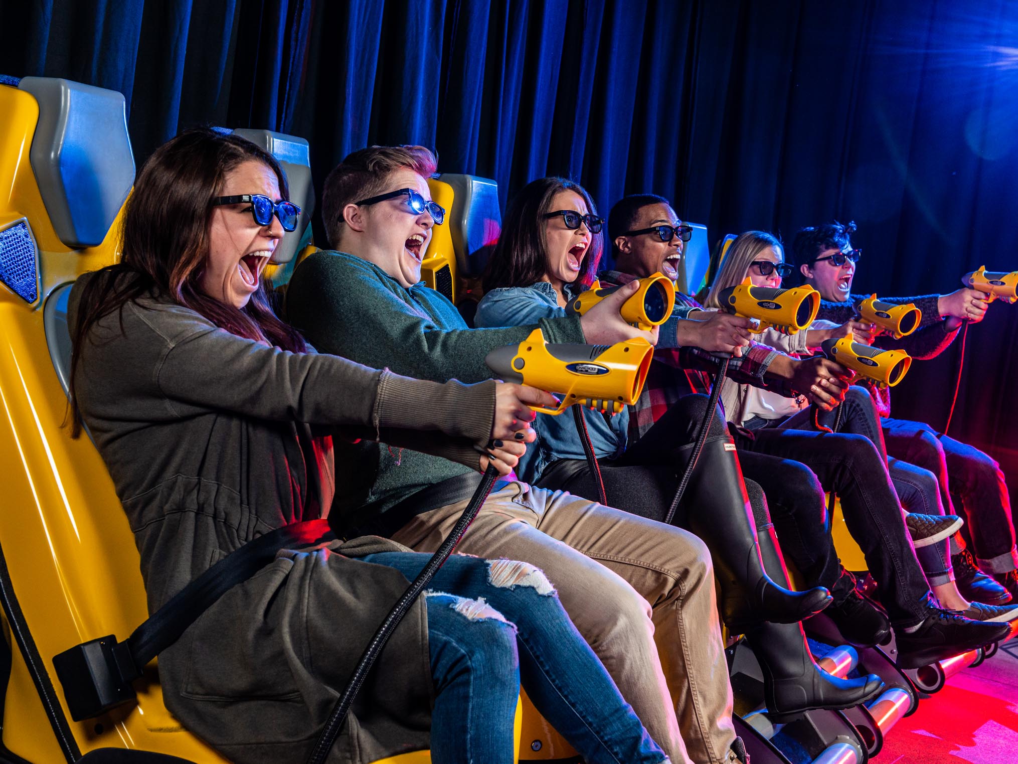 Group of young adults having fun in XD Dark Ride