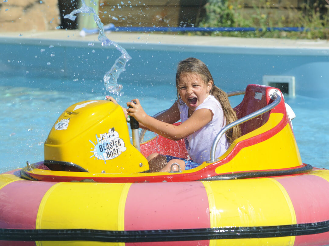 Young girl getting soaked on the bumper boats