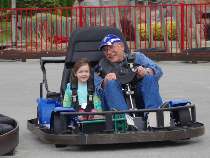 Grandpa and granddaughter driving on the go kart track