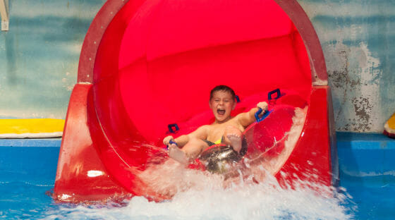 Young boy having fun sliding down a waterslide