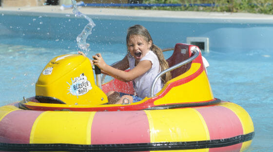 Young girl getting soaked on the bumper boats