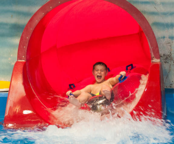 Young boy having fun sliding down a waterslide