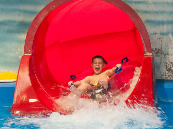 Young boy having fun sliding down a waterslide