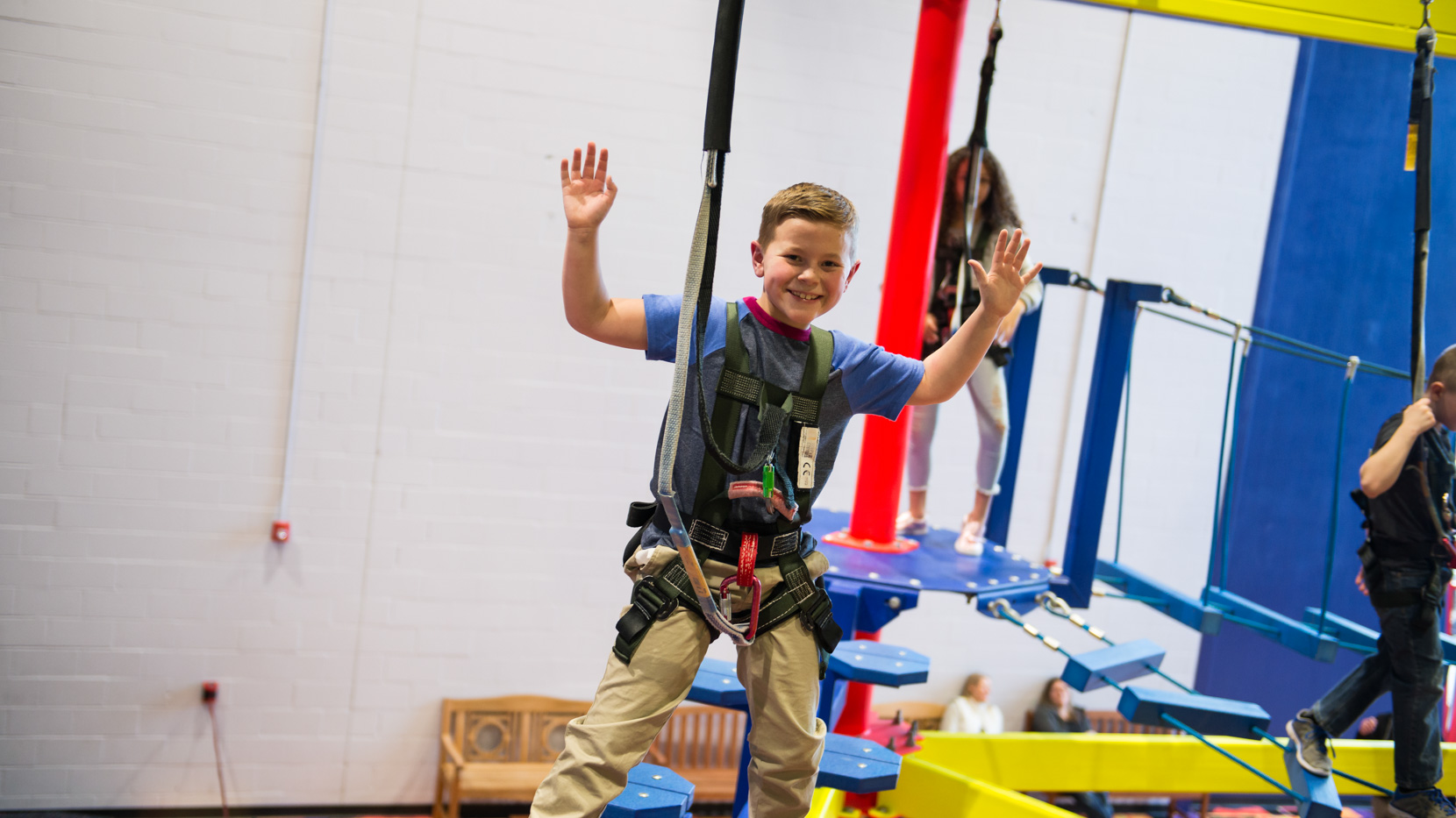 Young boy in a harness on the ropes course