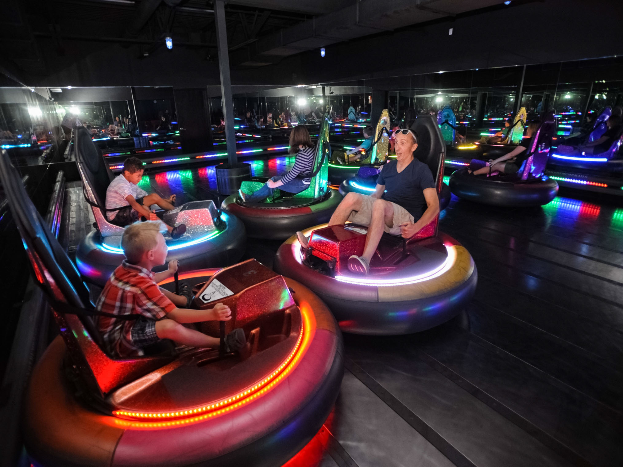 Adults and kids riding bumper cars