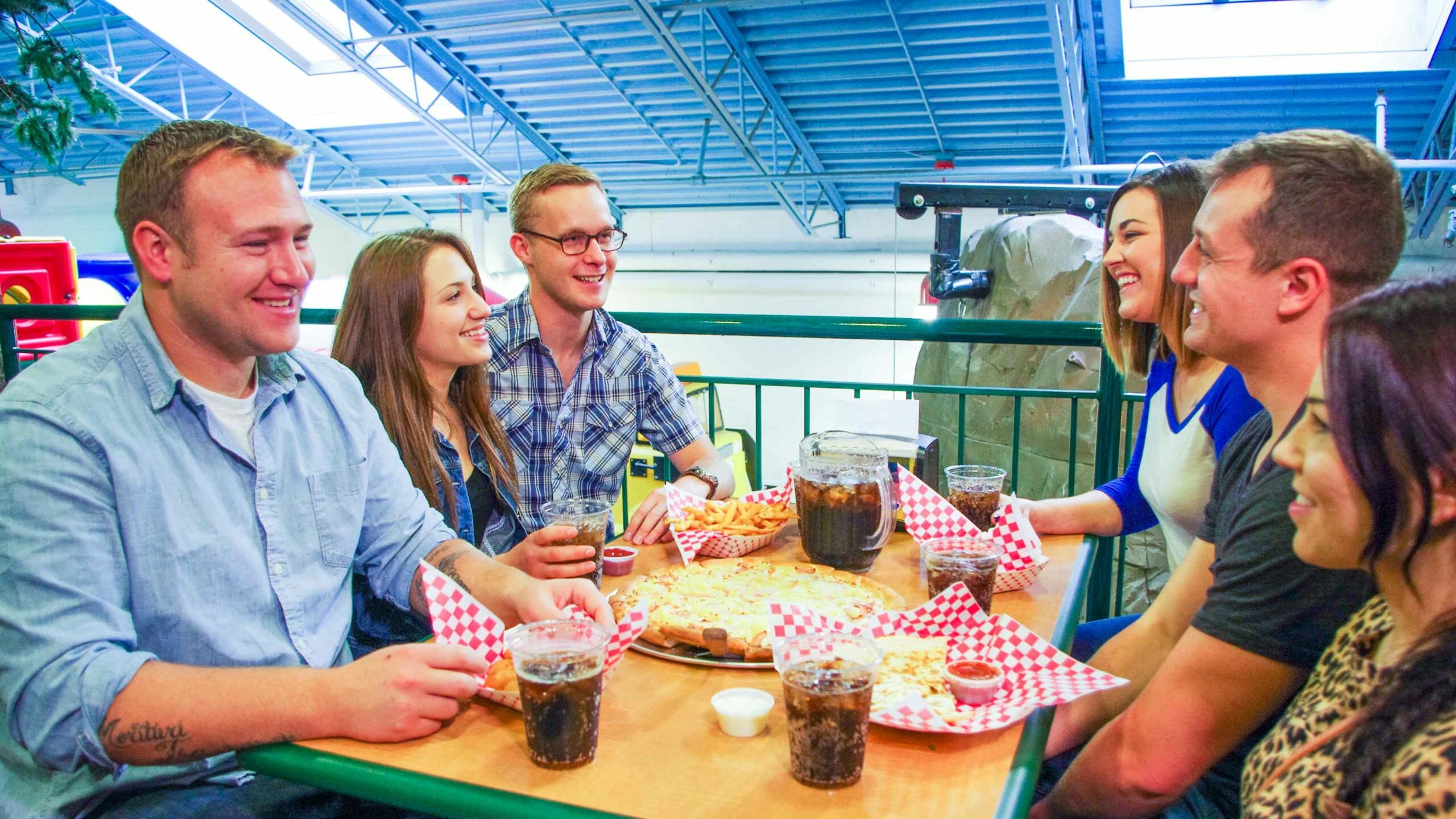 Young professionals sitting at a table eating food and laughing together