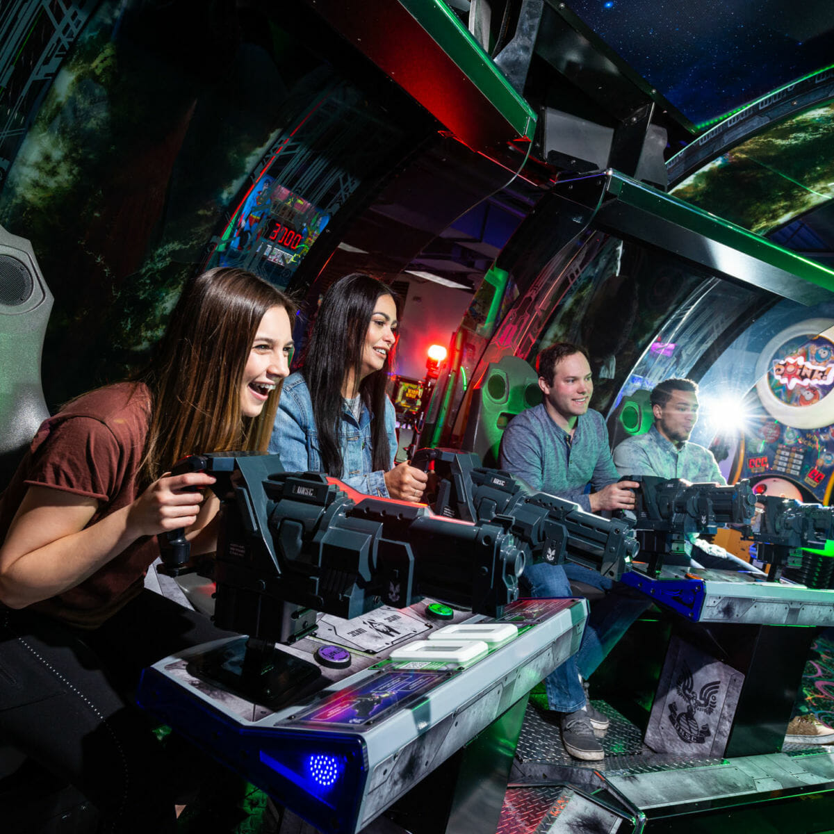 Group of young adults playing an arcade shooter game
