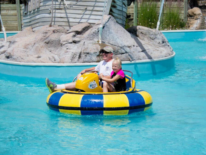Dad and daughter in a bumper boat having fun