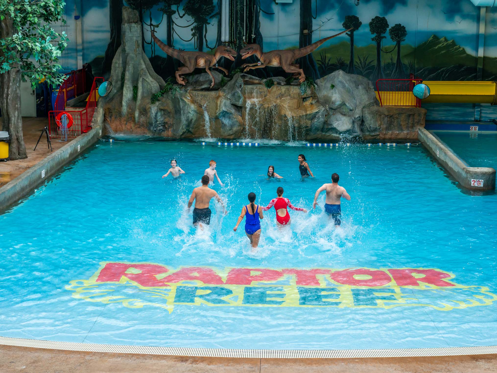 Adults and children running in the wave pool