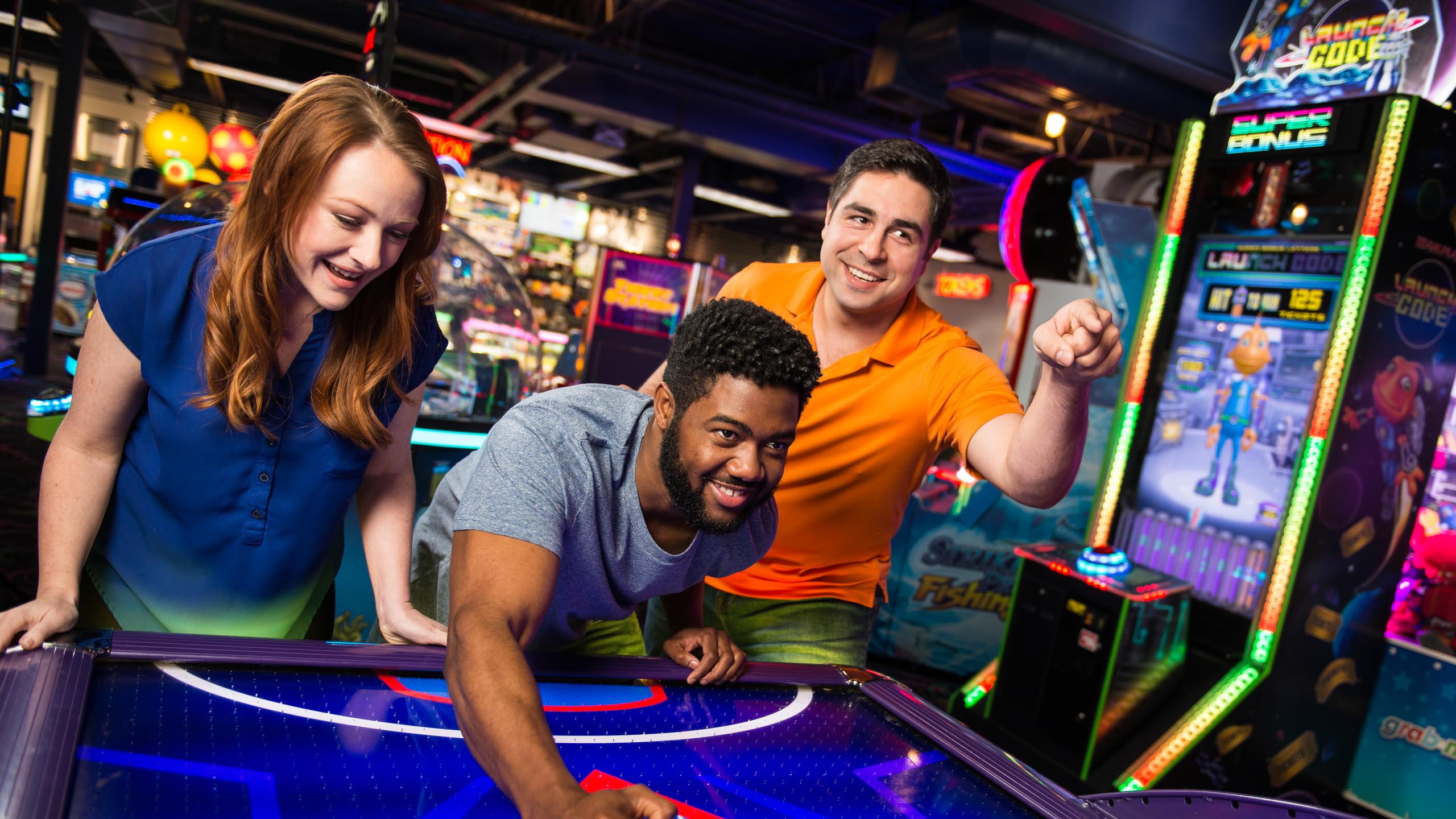Adults playing air hockey