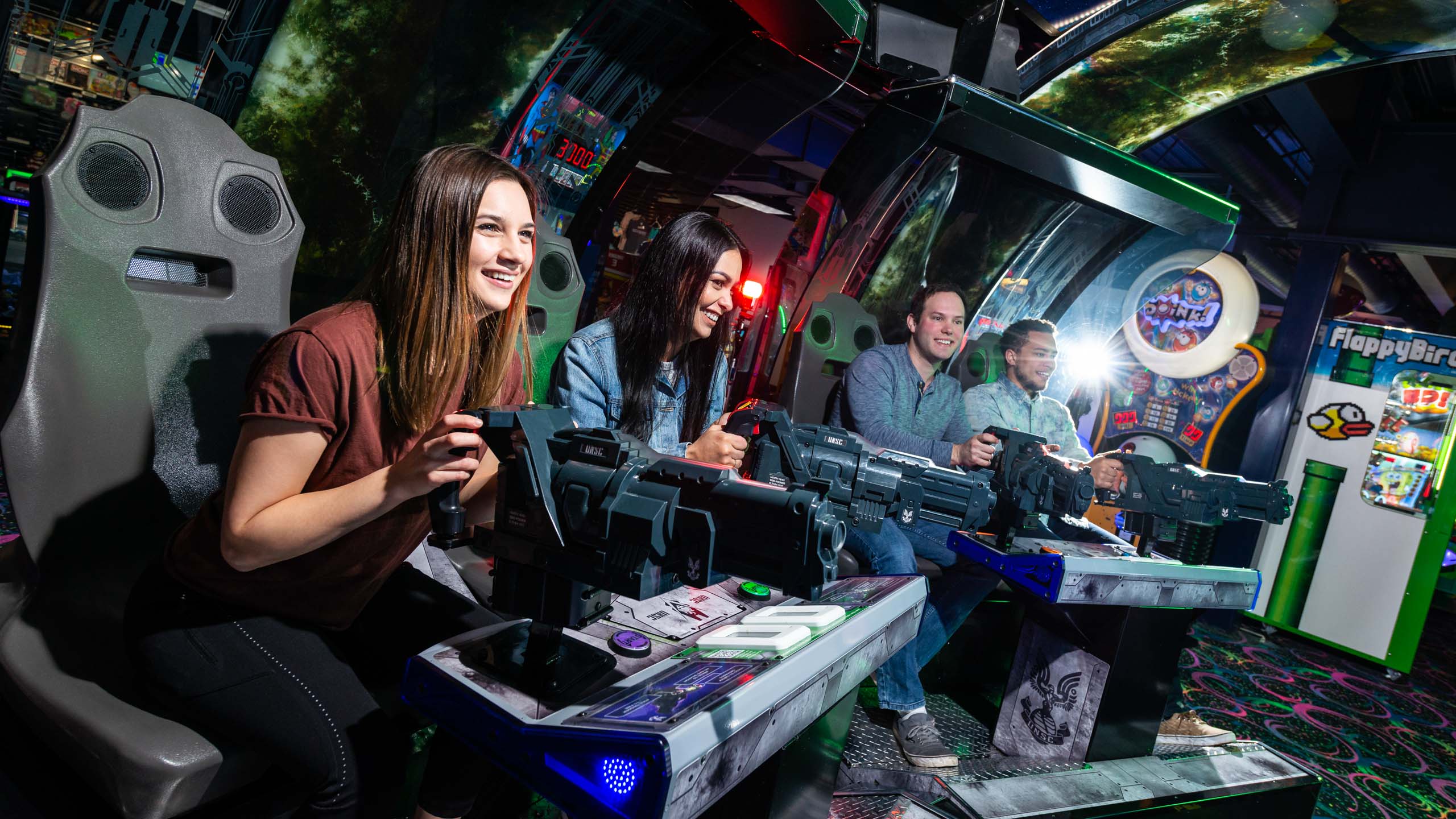 Group of four friends playing a game in the arcade together