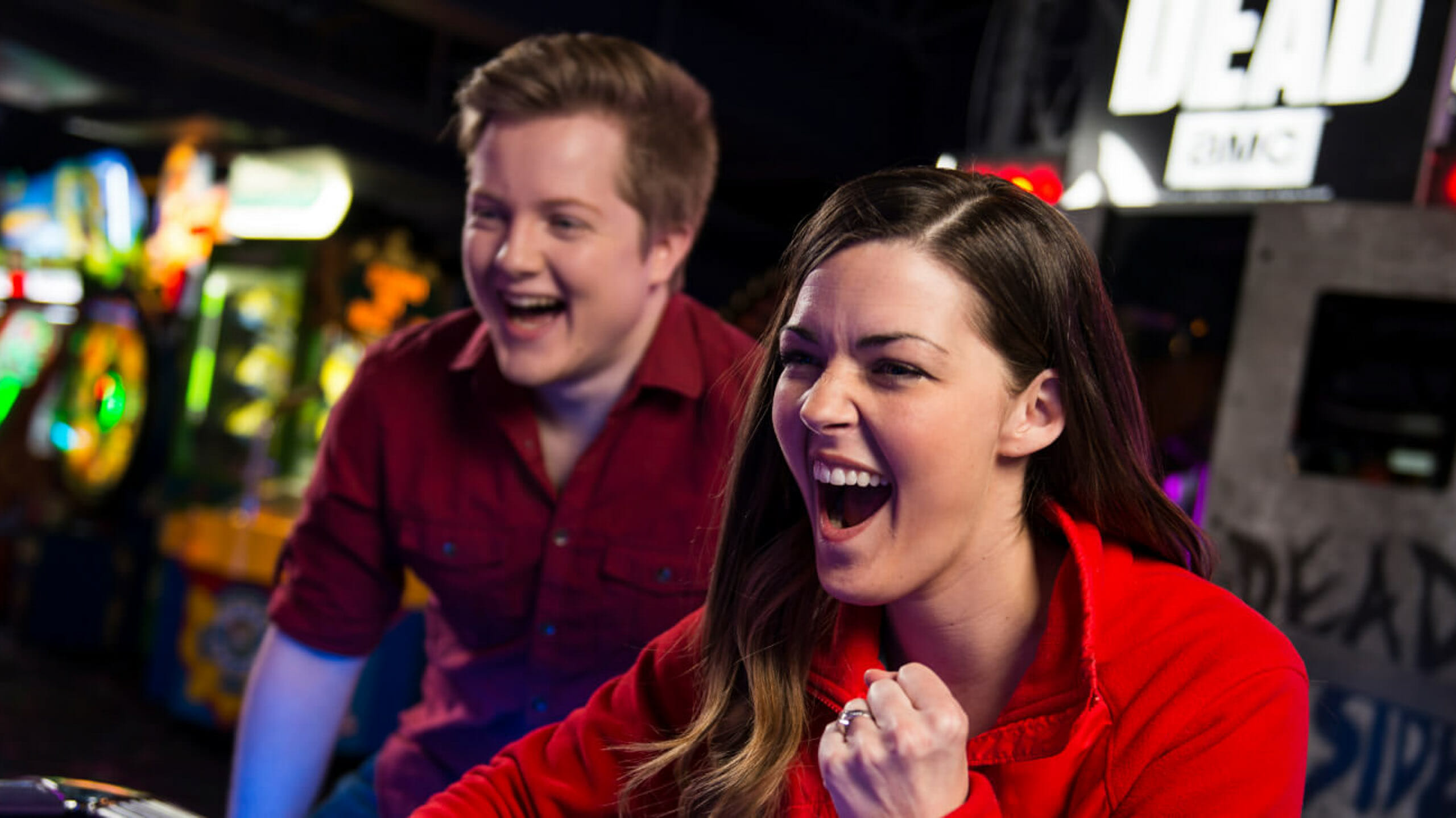 Adult woman excitedly playing air hockey
